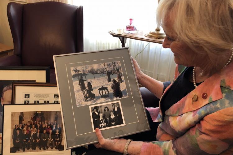 Libbe Hubley holds a frame image in her living room