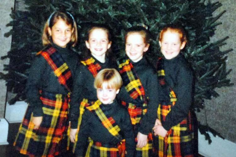 Five grandchildren pose in front of the Christmas evergreen at Government House