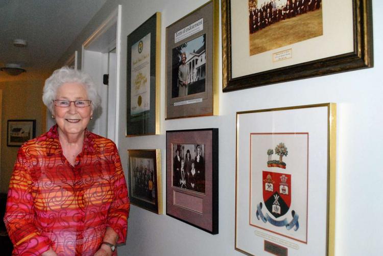 Hon. Marion Reid stands beside a display of memorabilia in her home