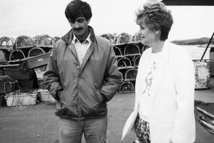 Black and white image of MP Catherine Callbeck speaking with a fisherman in her riding of Malpeque