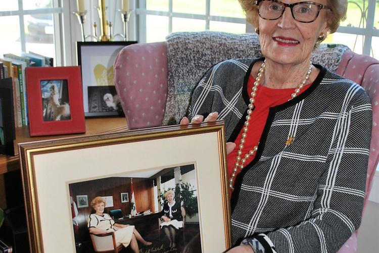 Catherine Callbeck holding image of herself and Kim Campbell as Canada's only female prime minister